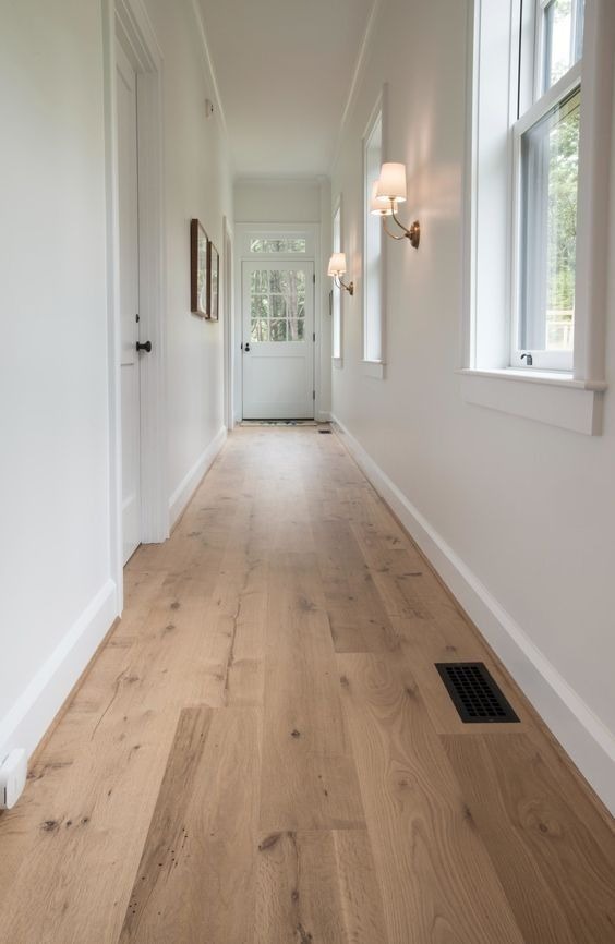 Wide plank natural oak hardwood flooring installed in residential hallway
